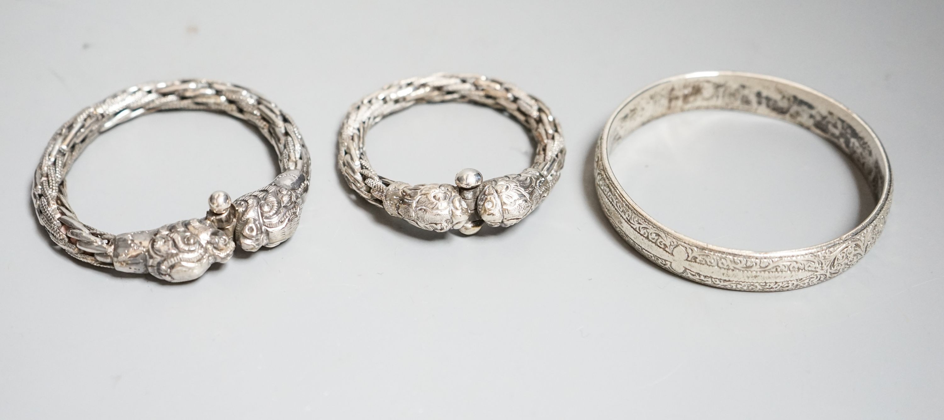 A cased Edwardian belt buckle, Goldsmiths & Silversmiths Co Ltd, London, 1908 and three bangles.
